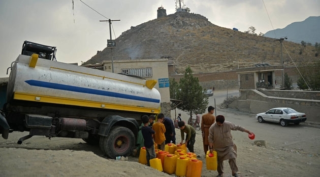 People fetch drinking water from a tanker in Kabul on October 1, 2021. 