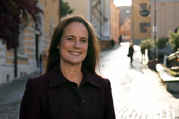 Porträttbild på Jenny Helin i halvfigur utomhus i Visby en solig dag.
