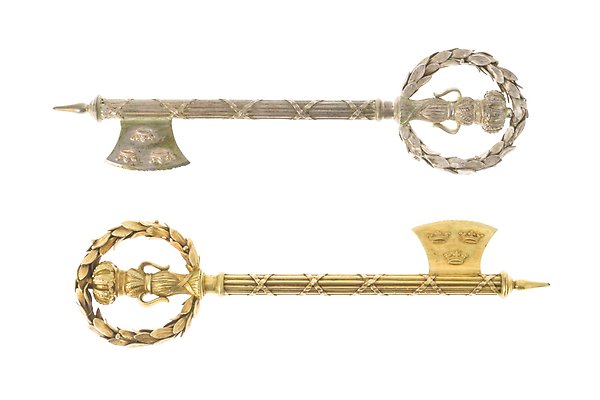 Two gilded keys side by side. They are distinguished by decorative details.