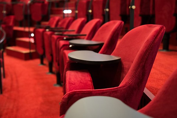 Red chairs in rows in an auditorium