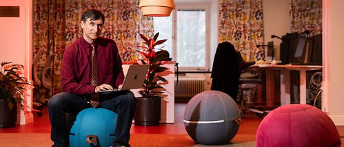 Matteo Magnani sitter med datorn i knät på en sittpuff i form av en boll. 